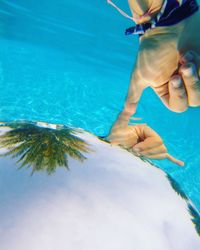 Low section of man swimming in pool