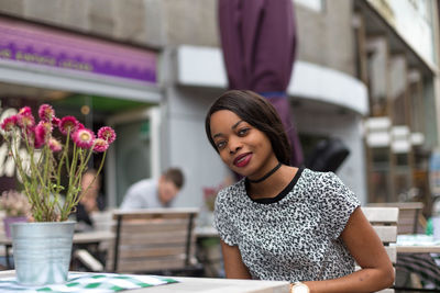 Portrait of smiling woman sitting at sidewalk cafe