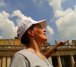 Portrait of young woman looking away against sky