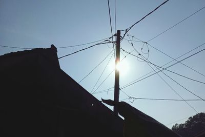 Low angle view of silhouette electricity pylon against sky