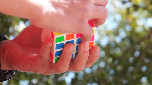 Extreme close up of hand holding colorful cube