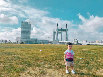 Full length of boy on field against sky