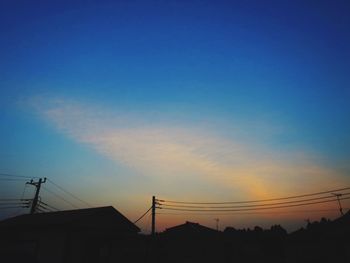 Low angle view of silhouette electricity pylon against romantic sky