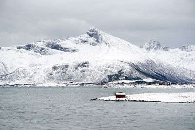 Scenic view of snowcapped mountains by sea against sky