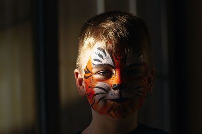 Portrait of boy with painted face at home