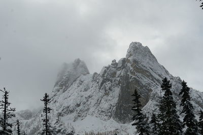 Low angle view of snowcapped mountains against sky