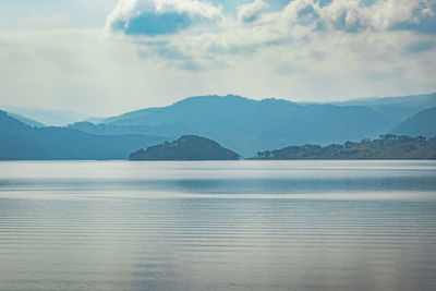 Scenic view of sea and mountains against sky