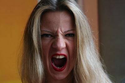 Close-up portrait of woman screaming indoors