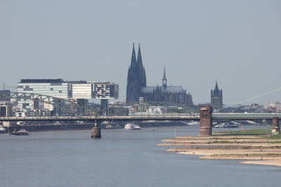 Bridge over river against buildings in city