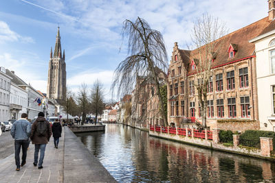 Tourists walking along the canal of bruges