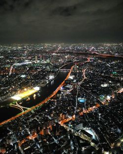 High angle view of illuminated city against sky at night