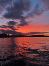 Scenic view of sea against dramatic sky during sunset