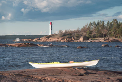 Lighthouse by sea against sky