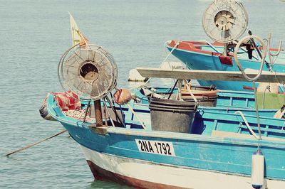 Close-up of boats moored on sea against sky