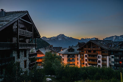 Houses and buildings against sky at sunset