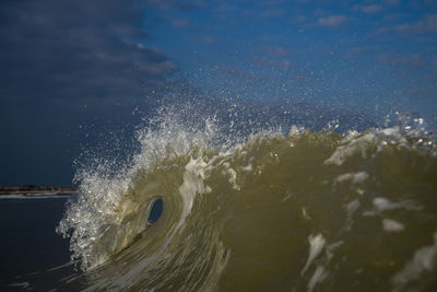 Water splashing in sea against sky