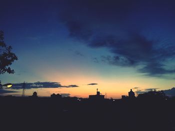 Silhouette cityscape against sky at dusk