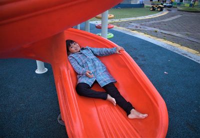 High angle view of boy sitting on road