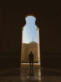 Rear view of silhouette man standing in mosque