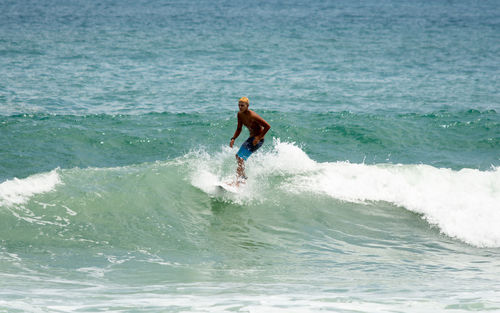 Full length of man splashing water in sea