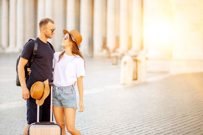 A young couple of travellers hugging in the city and enjoying romance. lovers smiling