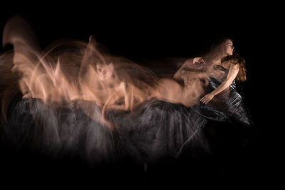 Midsection of woman against black background