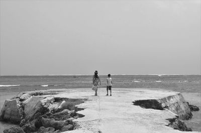 People on beach against clear sky