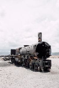 Steam train on land against sky