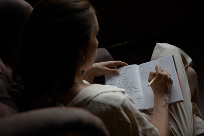 High angle view of woman writing in diary