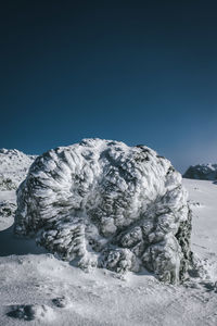 Snowcapped landscape against clear blue sky