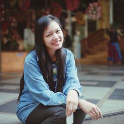 Portrait of smiling woman sitting outdoors