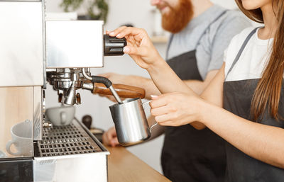 Midsection of woman having coffee in cafe