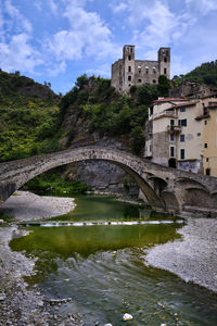 Arch bridge over river against buildings