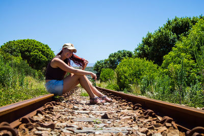 Full length of woman on railroad track against clear sky