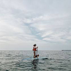 Man in sea against sky