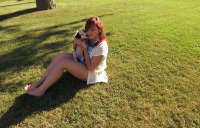 Full length of girl relaxing on grassy field