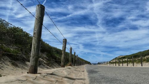 Panoramic shot of road amidst trees against sky