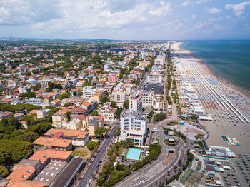 High angle view of city by sea against sky