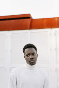 Confident young man wearing white turtleneck