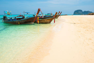 Boat moored on beach against sky