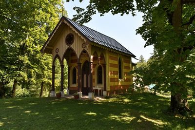 Low angle view of building by trees against sky