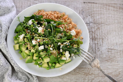 Gluten-free green vegetarian salad made of microgreen sprouts peas, avocado, quinoa, spinach