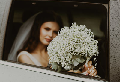 Bride with a bouquet of boutonnieres in the car.
