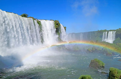 Incredible rainbow over the powerful iguazu falls at brazilian side, foz do iguacu, brazil