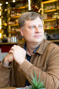 A grown man blond 40-45 years in a corduroy jacket sitting cafe at a table.