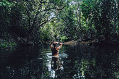 Back view of woman swimming in lake