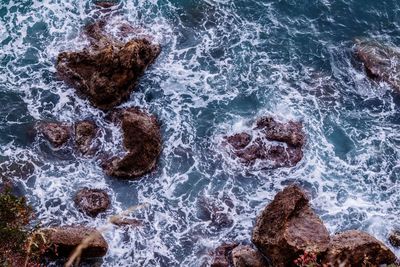 High angle view of waves splashing on rocks