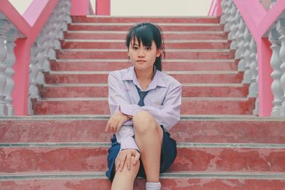 Portrait of woman sitting on staircase