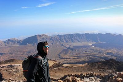 Man standing on mountain against sky during winter