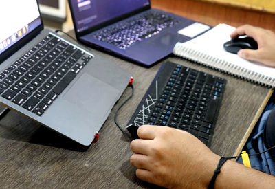 Cropped hands using laptop on table